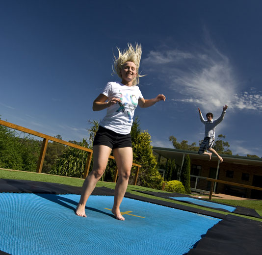 Blonde Girl jumping on a trampoline