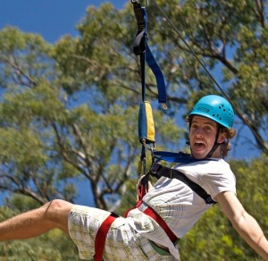 man in blue helmet flying down the zipline