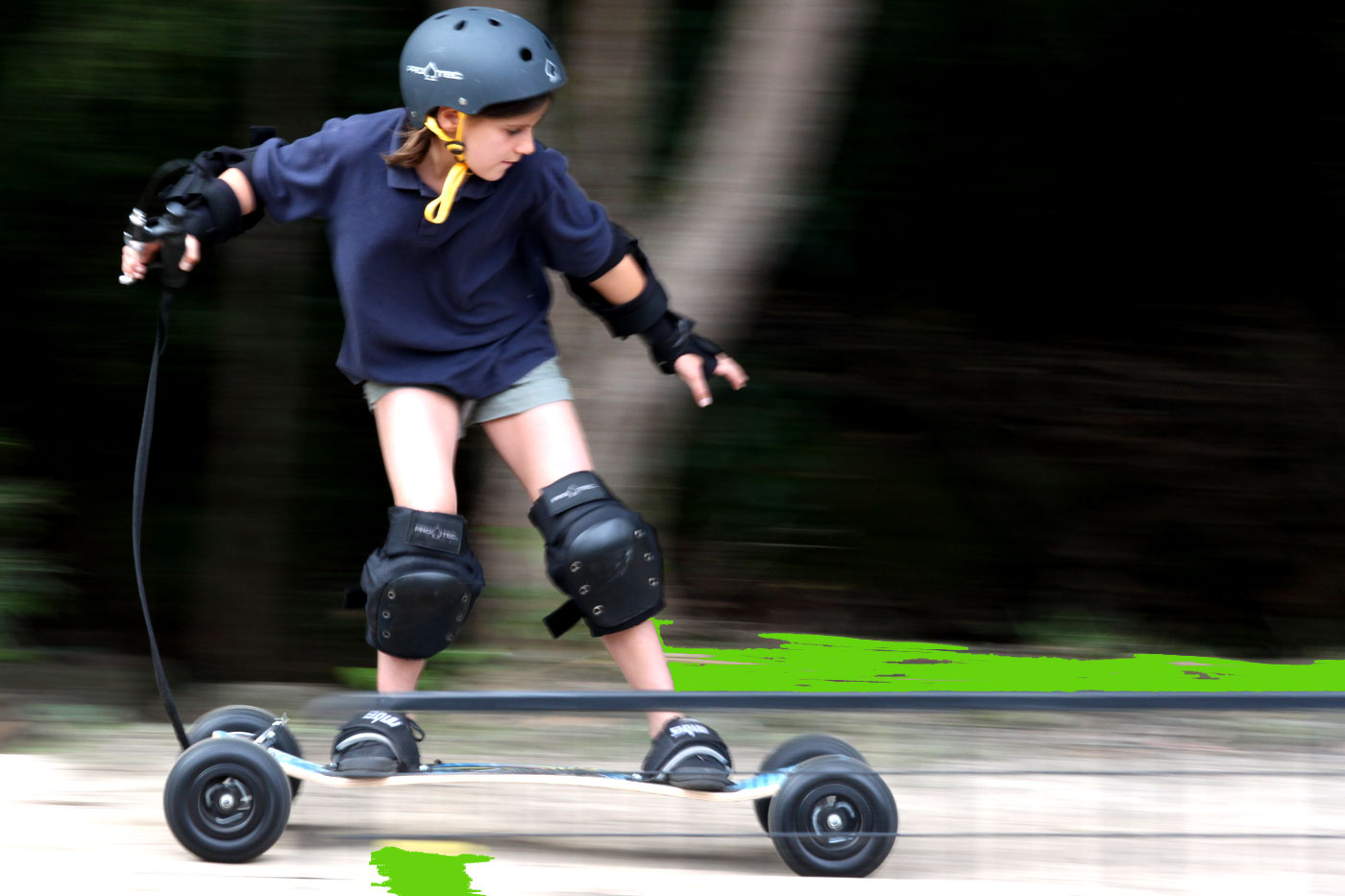 Picture of a kid at speed, on a mountain board